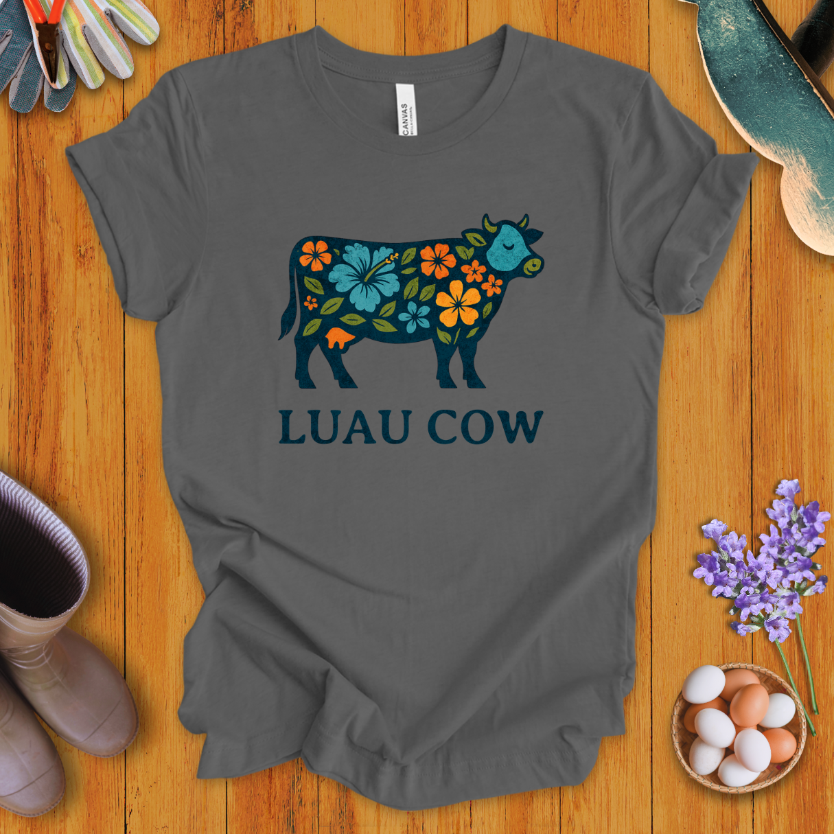 Floral luau cow graphic on asphault t-shirt with bold text “LUAU COW”