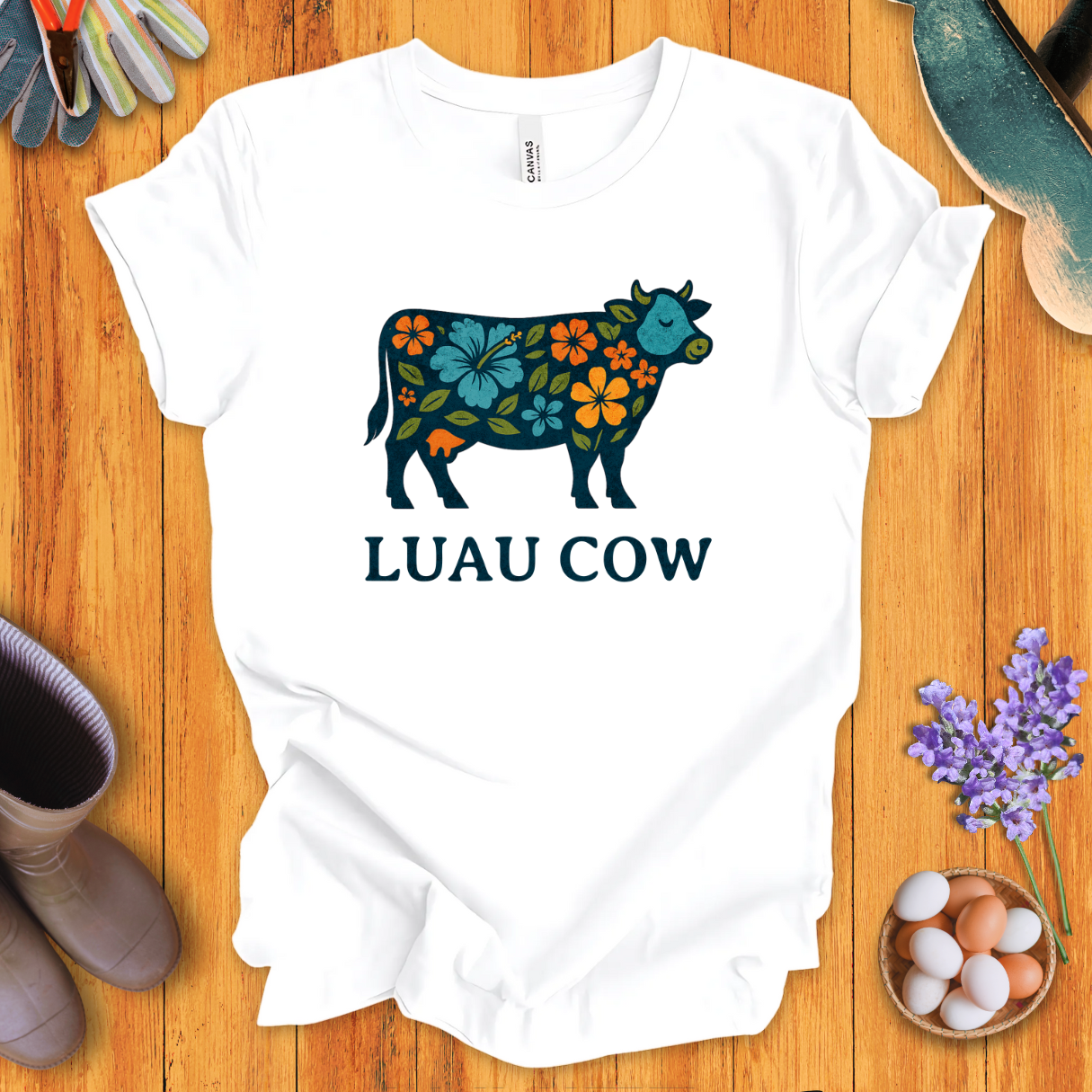 Floral luau cow graphic on white t-shirt with bold text “LUAU COW”